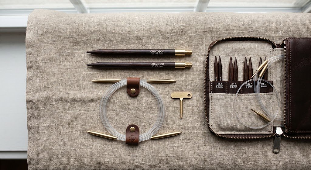 Interchangeable circular knitting needle tips, cable, and tightening key laid out before assembly
