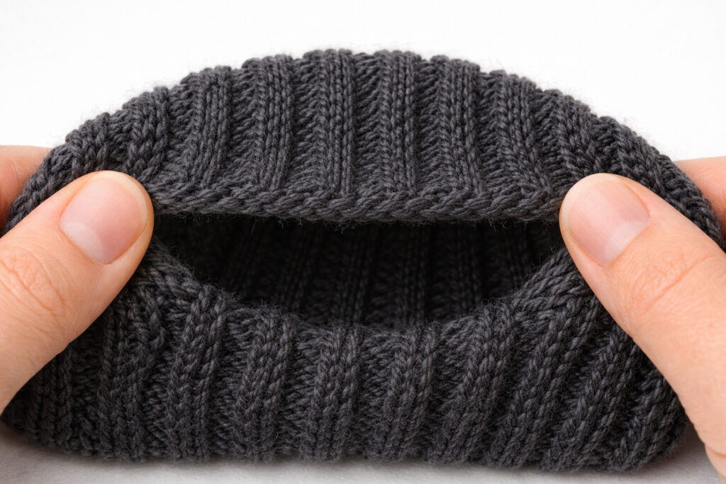 Example of common knitting mistake showing too-tight bind-off edge causing uncomfortable restriction on sock or hat