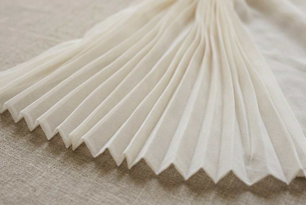 Ivory chiffon fabric pressed into narrow accordion pleats