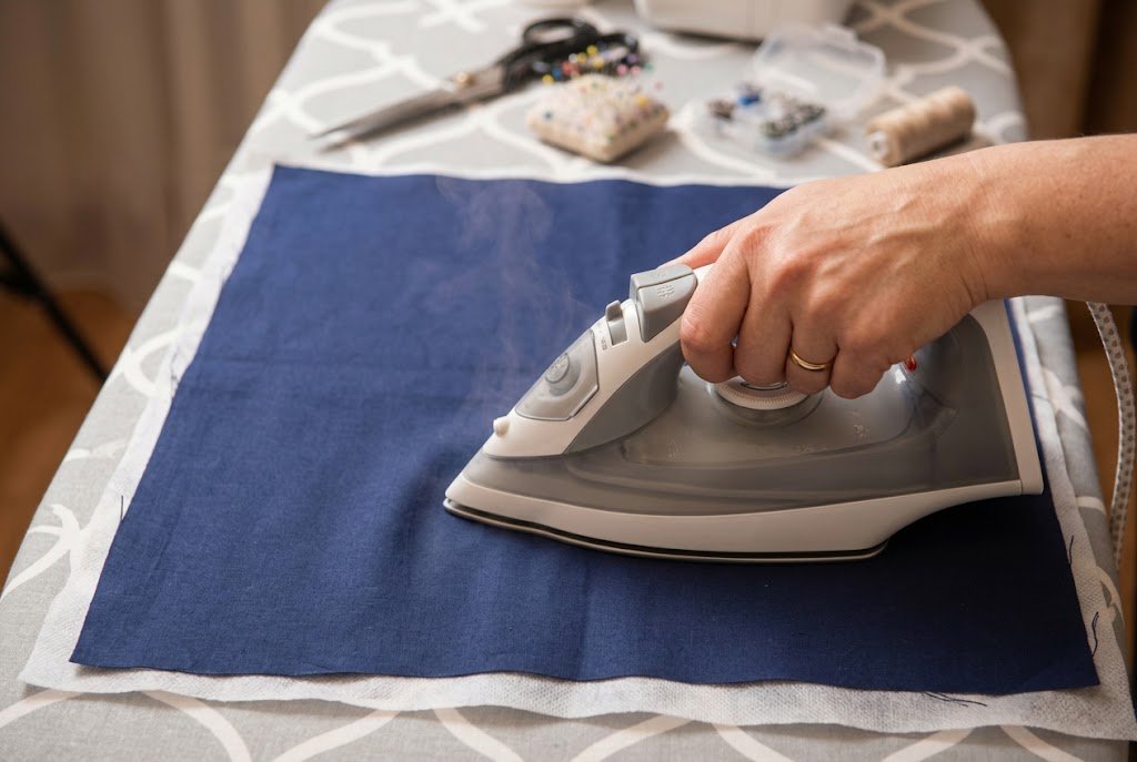 Pressing an iron over fabric to fuse interfacing in place