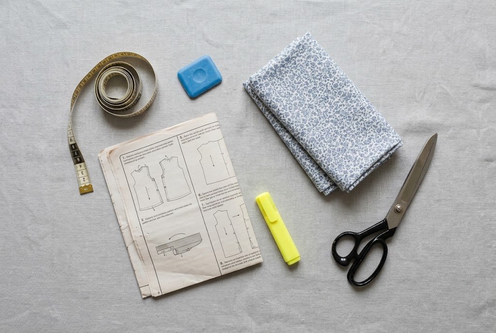 Sewing preparation tools including tape measure, chalk, and pattern instructions arranged for a pre-cutting routine