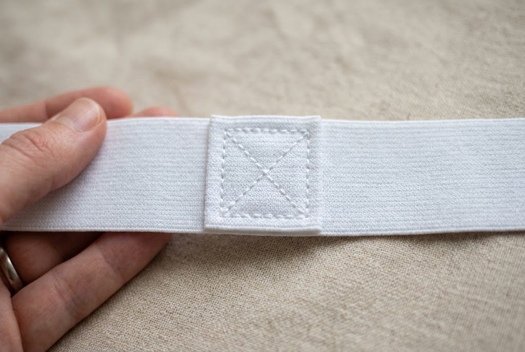 Overlapped elastic ends secured with a box stitch with an X for a strong join