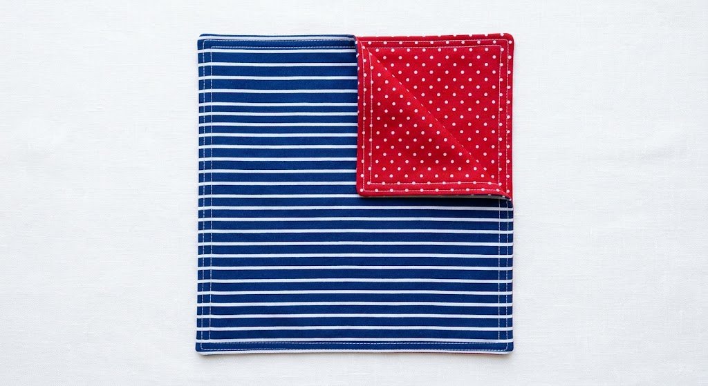 Reversible bandana showing two coordinating cotton prints with a topstitched border